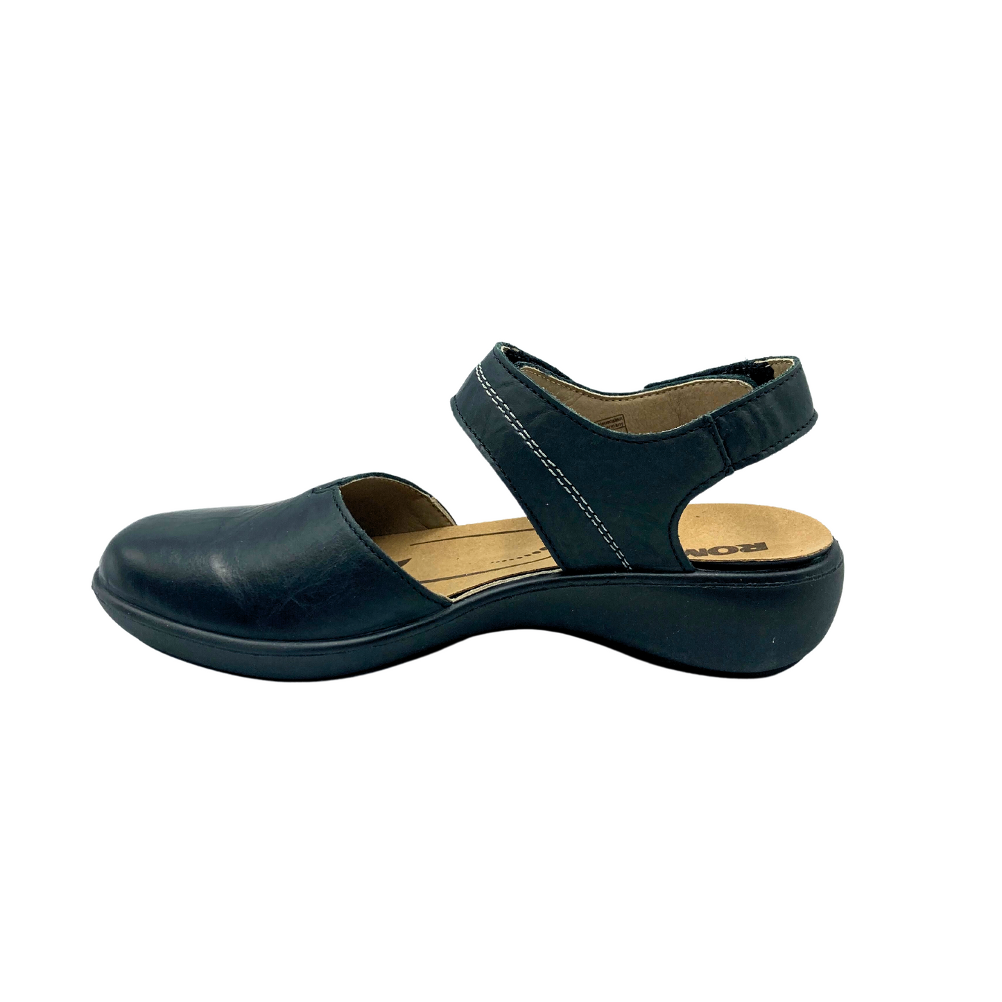 Inside view of a walking sandal in a black leather. Closed toe and open heel with adjustment at both the cross strap and heel strap. White stitch detail across teh top strap