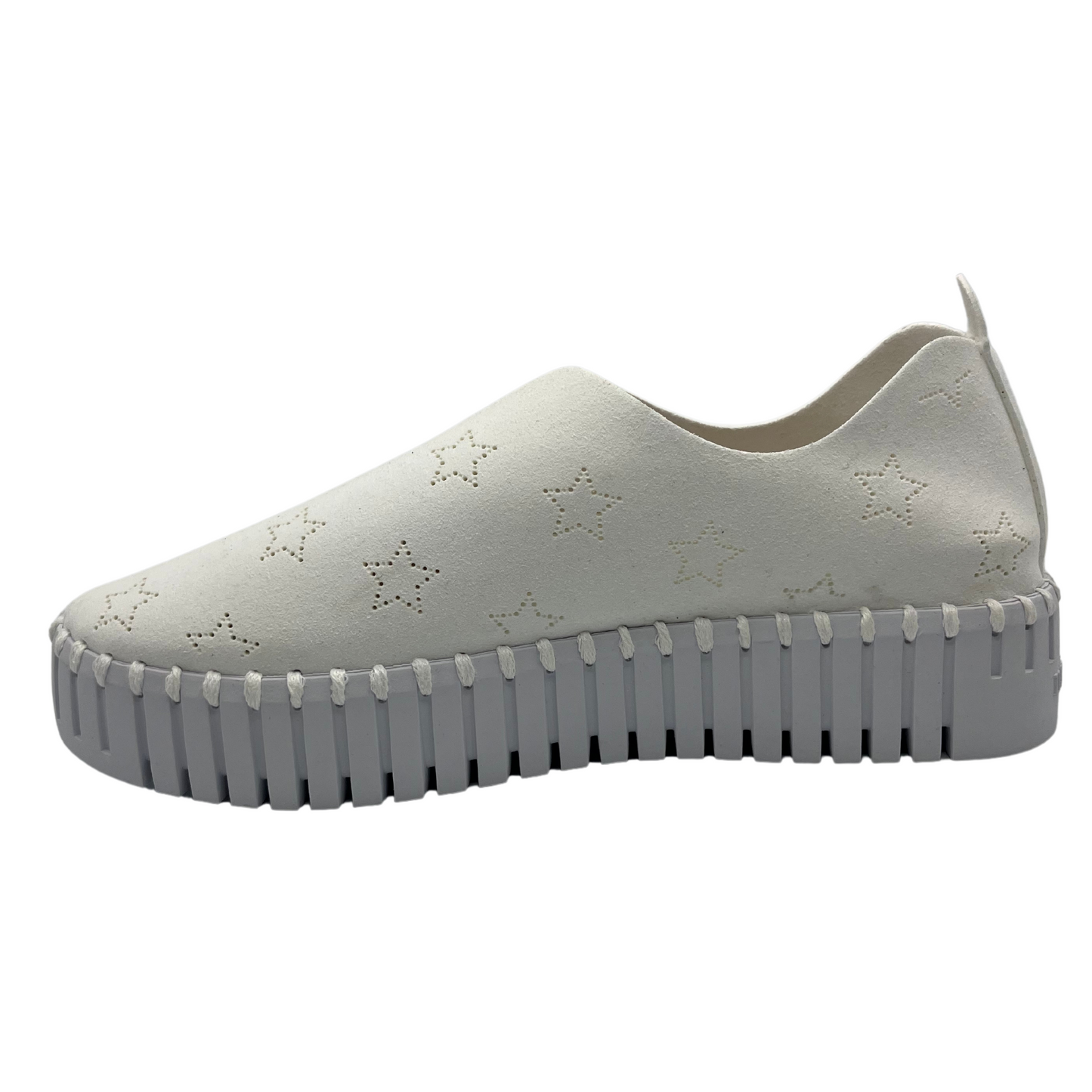 Left facing view of white slip on sneakers with small star cutouts on upper. White rubber platform sole.