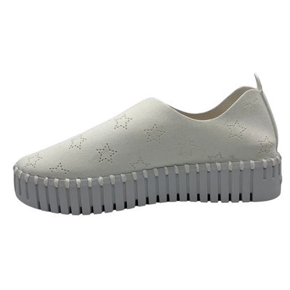 Left facing view of white slip on sneakers with small star cutouts on upper. White rubber platform sole.