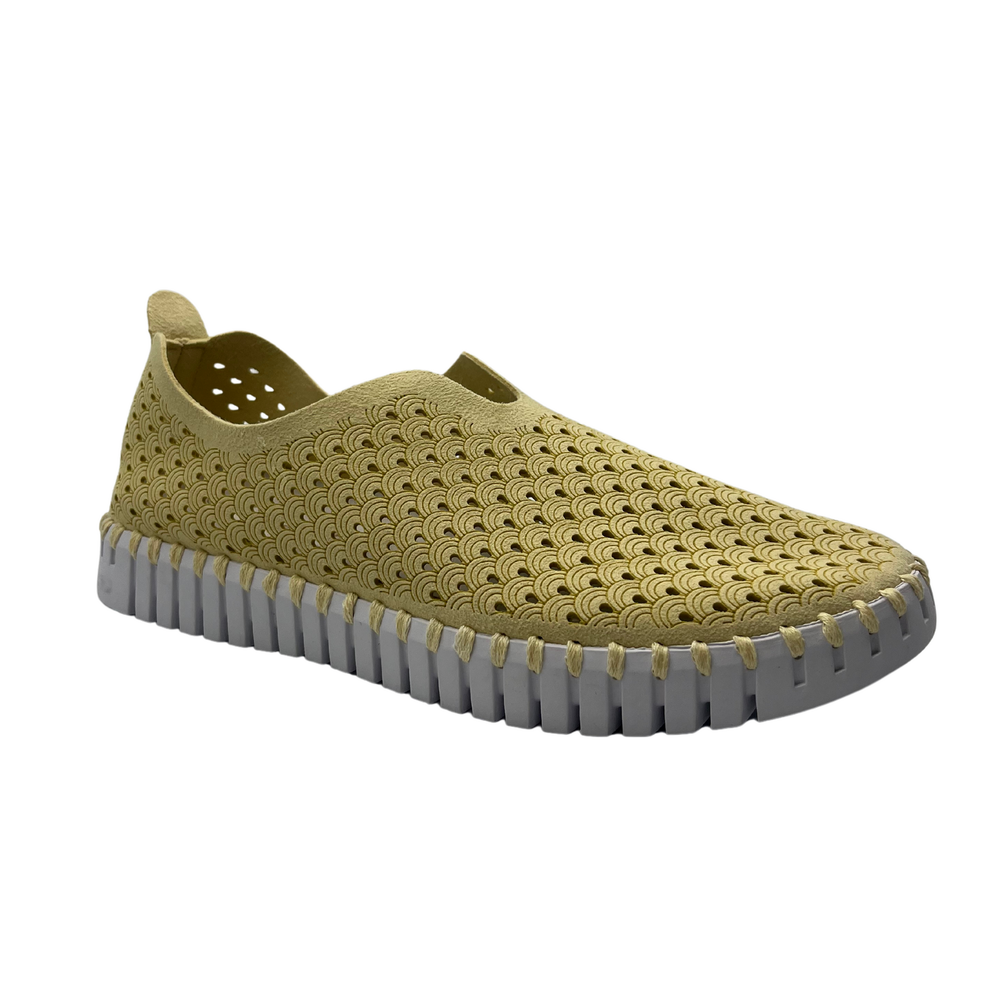 45 degree angled view of cream coloured slip on shoe with mesh design and white rubber outsole