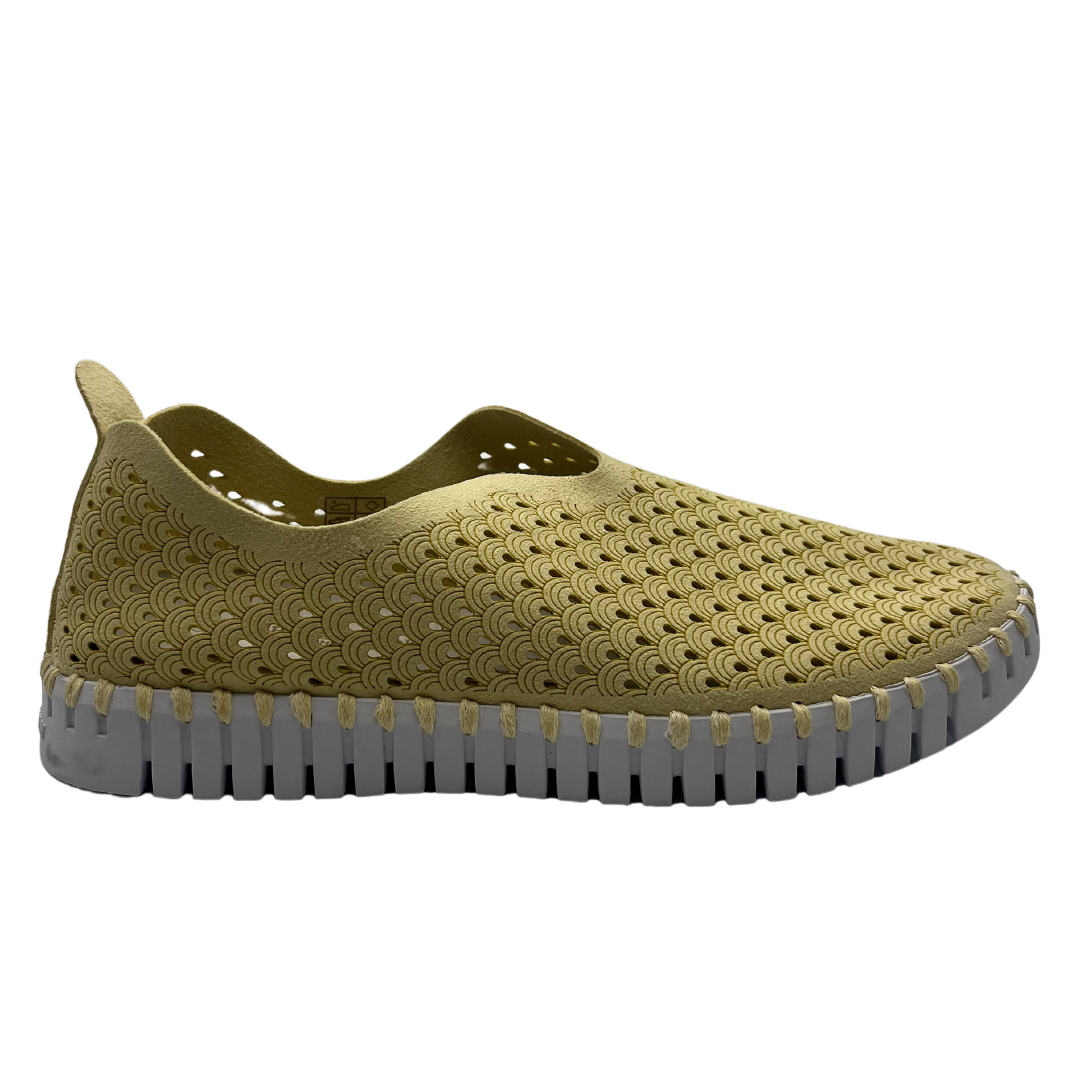 Right facing view of cream coloured slip on shoe with mesh design and white rubber outsole