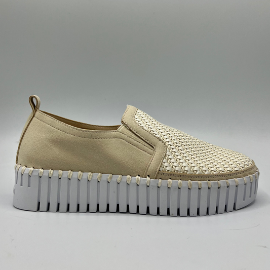 Right facing view of a beige and white shoe with elastic panels, a pull on heel tab, and a white rubber outsole.