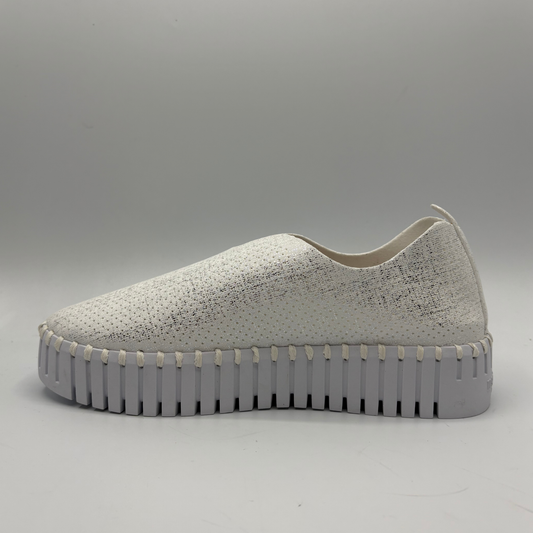 White slip-on sneaker with a thick gray sole on a light gray background