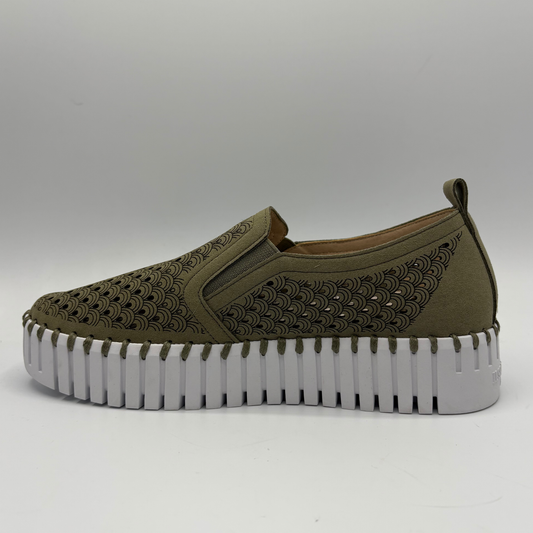 Green slip-on shoe with a thick white sole on a gray background