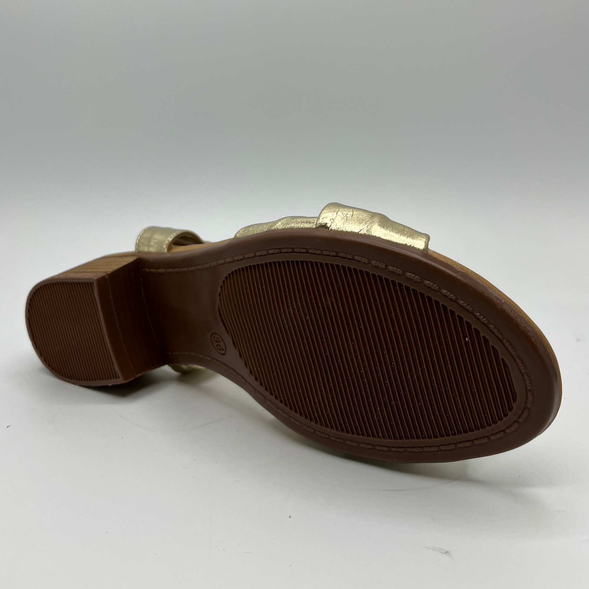 Bottom view of a gold leather sandal with a tan leather wrapped footbed and a short stacked heel.