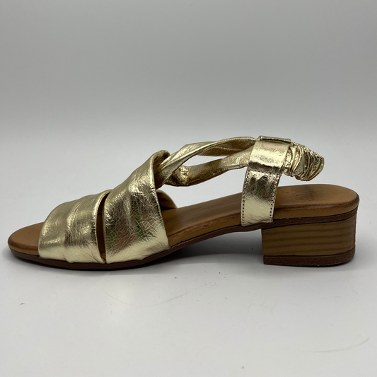 Left view of a gold leather sandal with a tan leather wrapped footbed and a short stacked heel.
