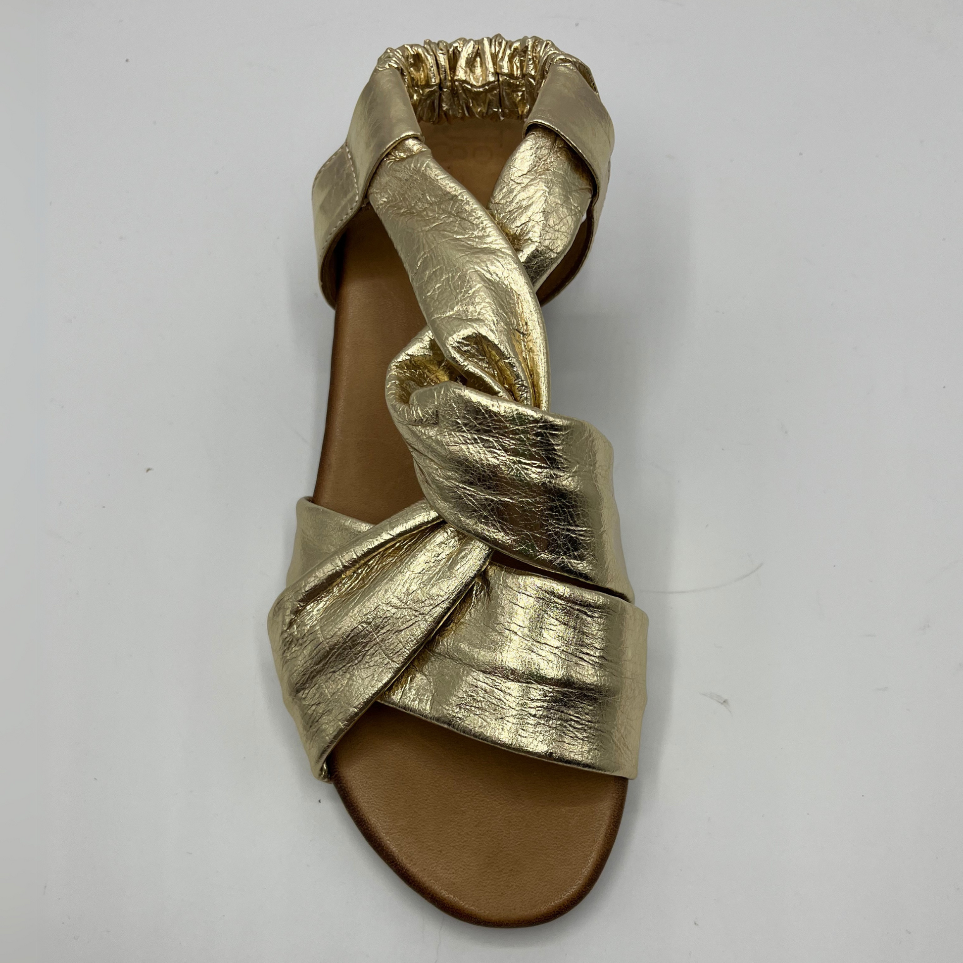 Top view of a gold leather sandal with a tan leather wrapped footbed and a short stacked heel.
