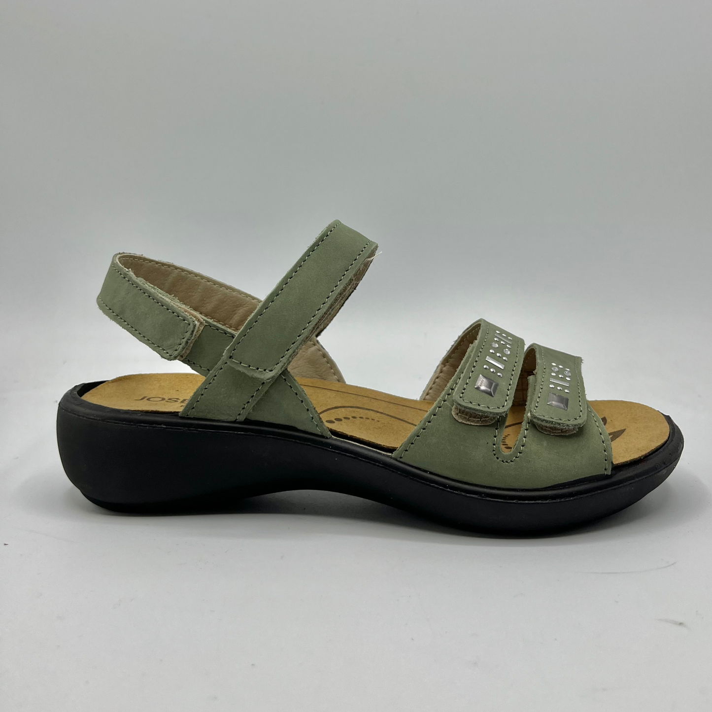 Right facing view of a green nubuck leather sandal with 4 adjustable hook and loop straps, a contoured footbed and a black outsole.