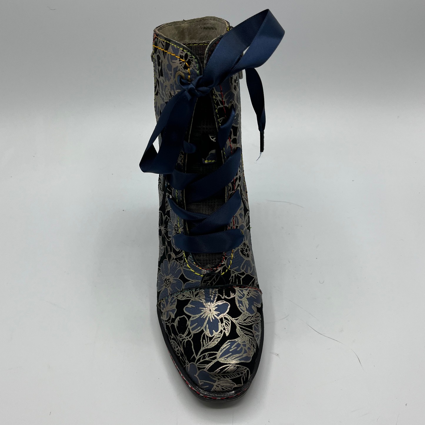 Floral-patterned boot with blue laces on a white background