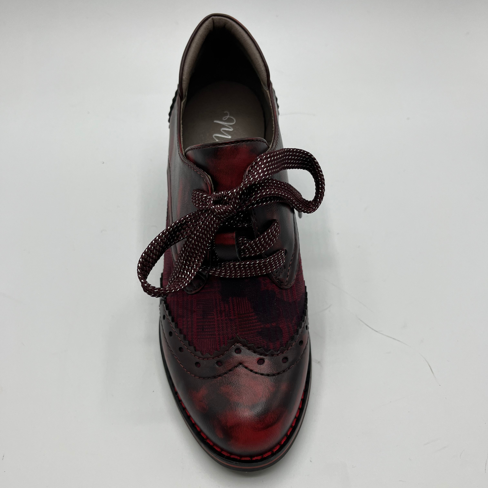 Red and black brogue shoe on a white background