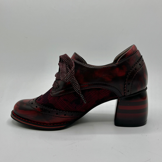 Burgundy leather shoe with decorative laces on a gray background