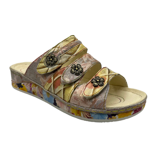 45 degree angled view of leather slip on sandal with low wedge heel and metal flower details on the straps