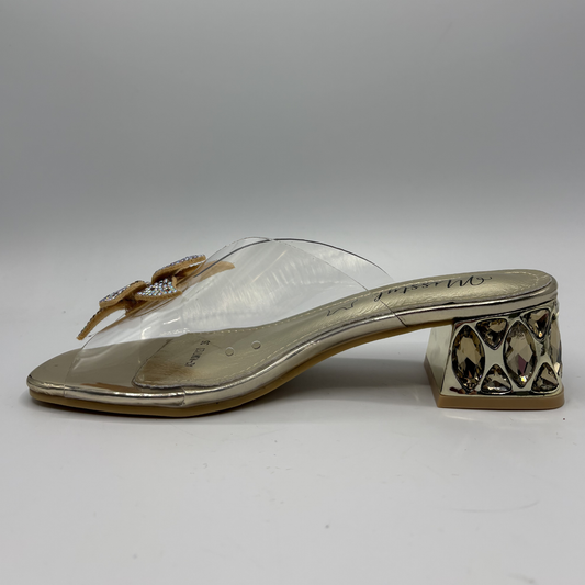 Clear sandal with decorative strap and low heel on a gray background