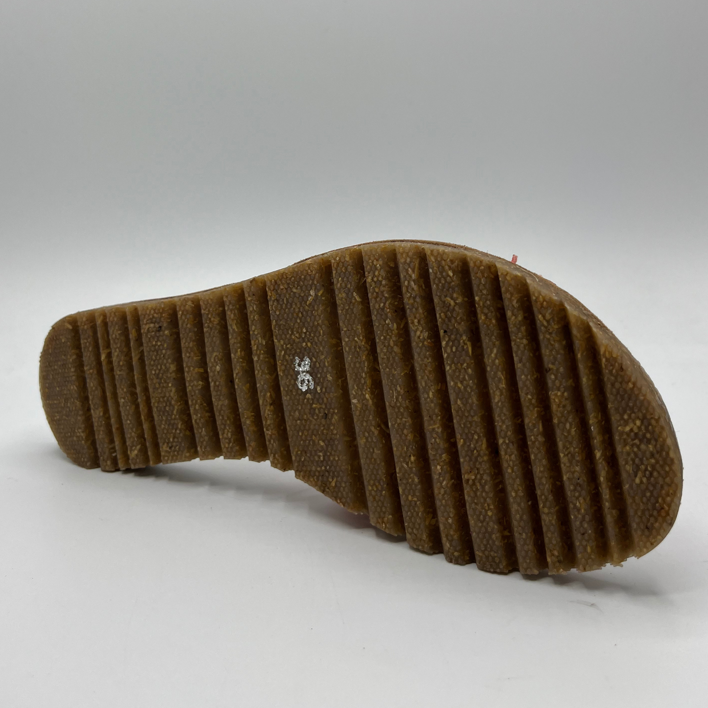 Back view of a coral slip on sandal with a handmade leather flower detail on the strap and a brown footbed.