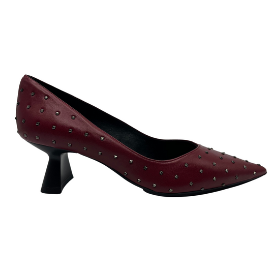 Right facing view of red leather pump with metallic studs and flared heel