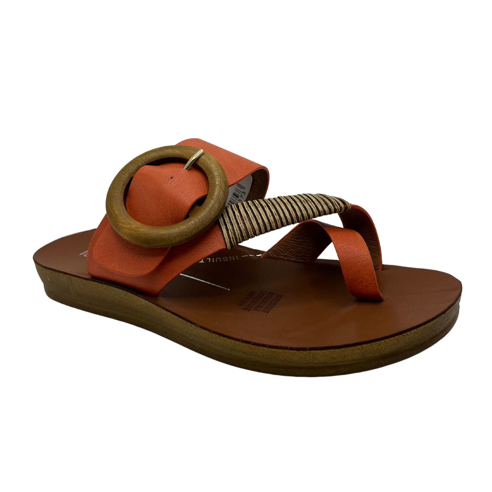 45 degree angled view of orange strapped slip on sandal. Featuring a wooden buckle and bamboo wrap on the toe strap.