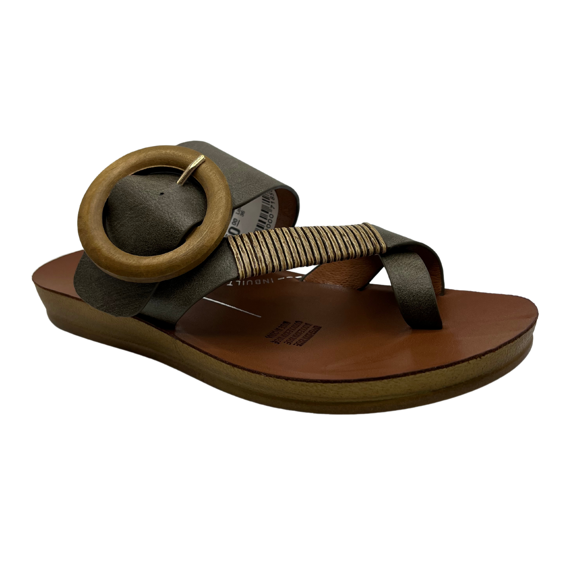 45 degree angled view of khaki strapped slip on sandal. Featuring a wooden buckle and bamboo wrap on the toe strap.