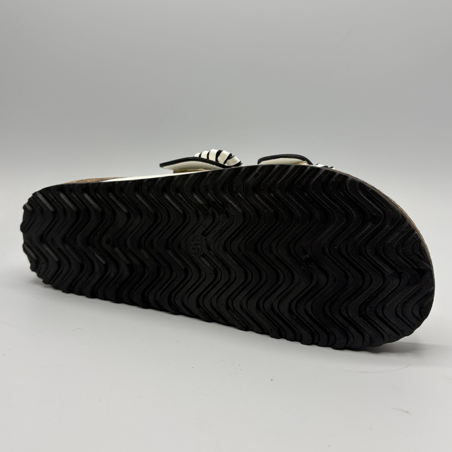 Black rubber sole of a shoe on a gray background