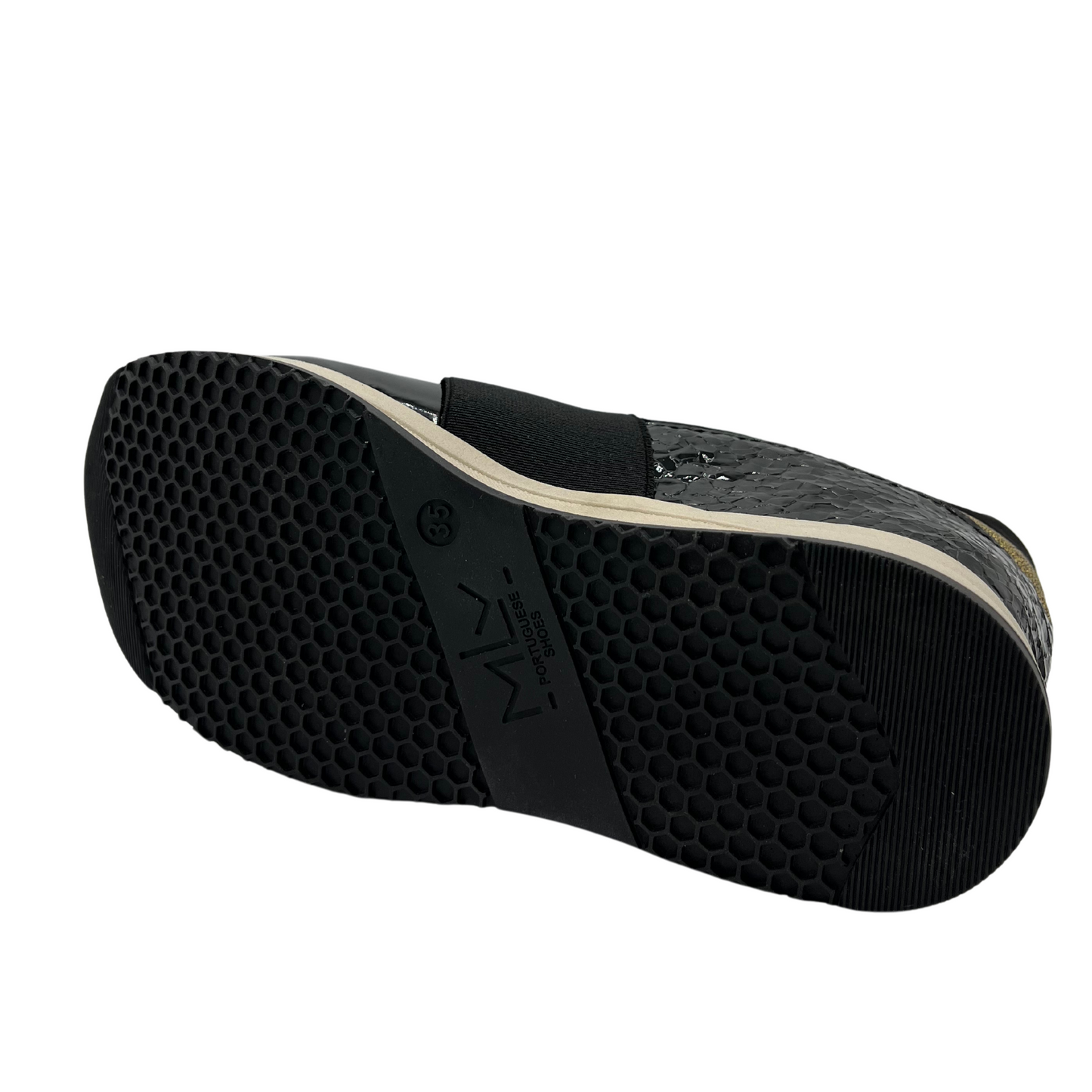 Bottom view of black hidden wedge sneakers with an elastic closure and beige outsole