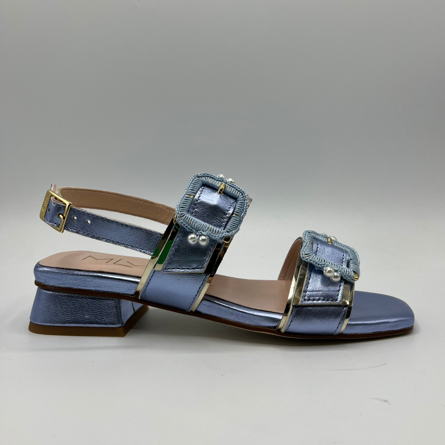Right facing view of a blue metallic leather sandal with a leather lining and upper. Large buckle straps and one delicate sling back strap. Low block heel and delicate pearl details on the buckles.
