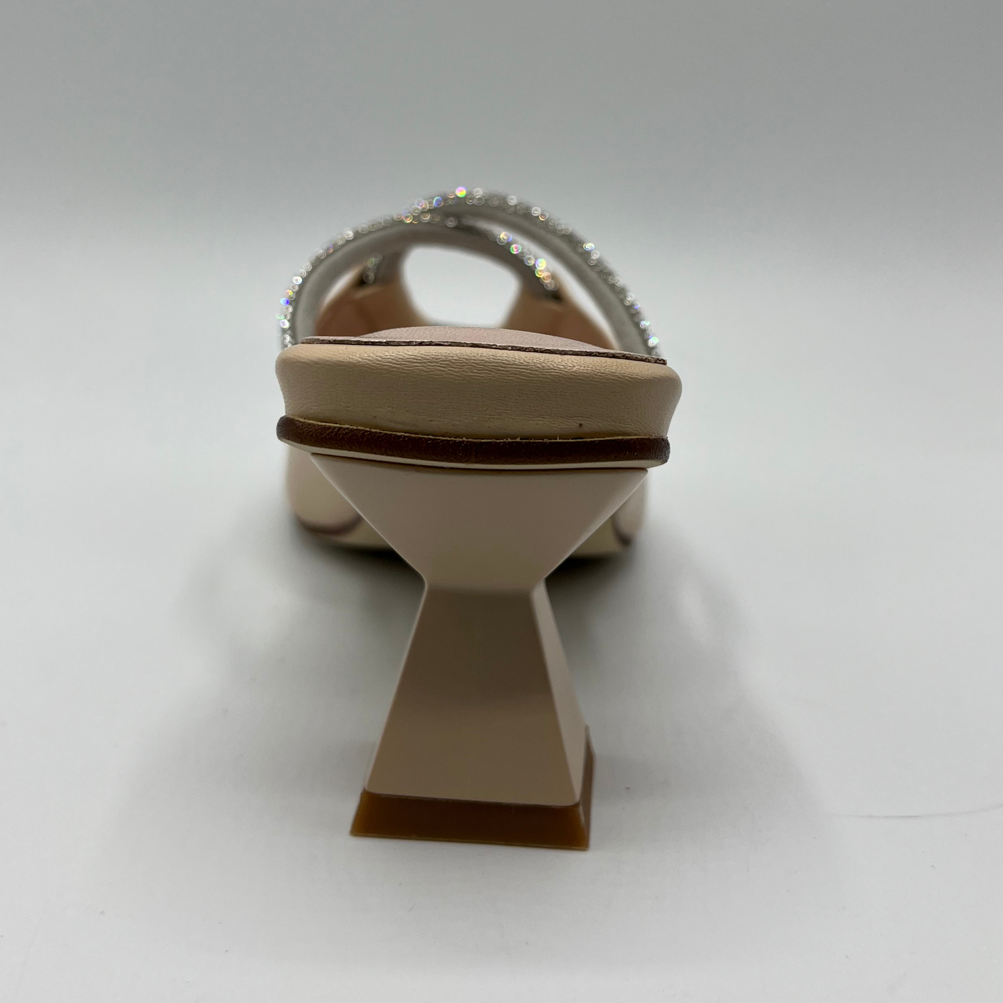 Back view of a beige leather sandal with a geometric flared heel, leather lining and a silver jewelled rope detail.