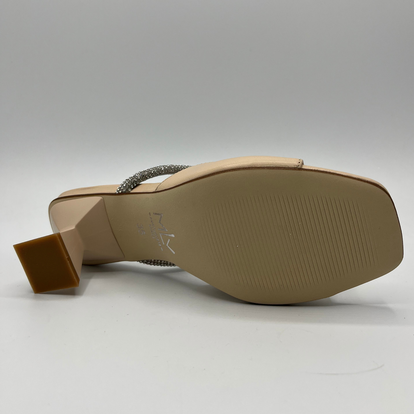 Bottom view of a beige leather sandal with a geometric flared heel, leather lining and a silver jewelled rope detail.