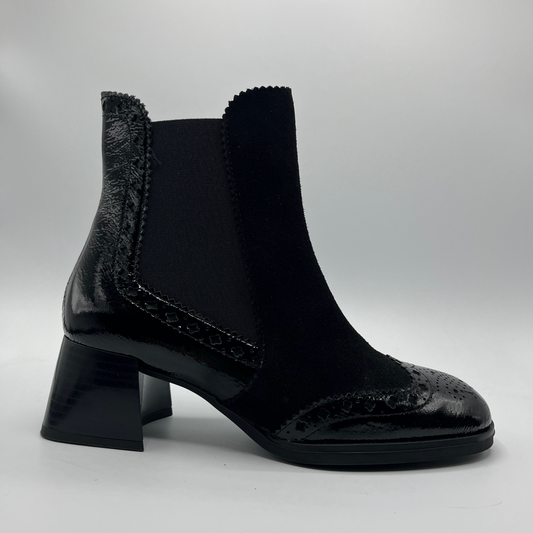 Black ankle boot with a block heel on a light gray background