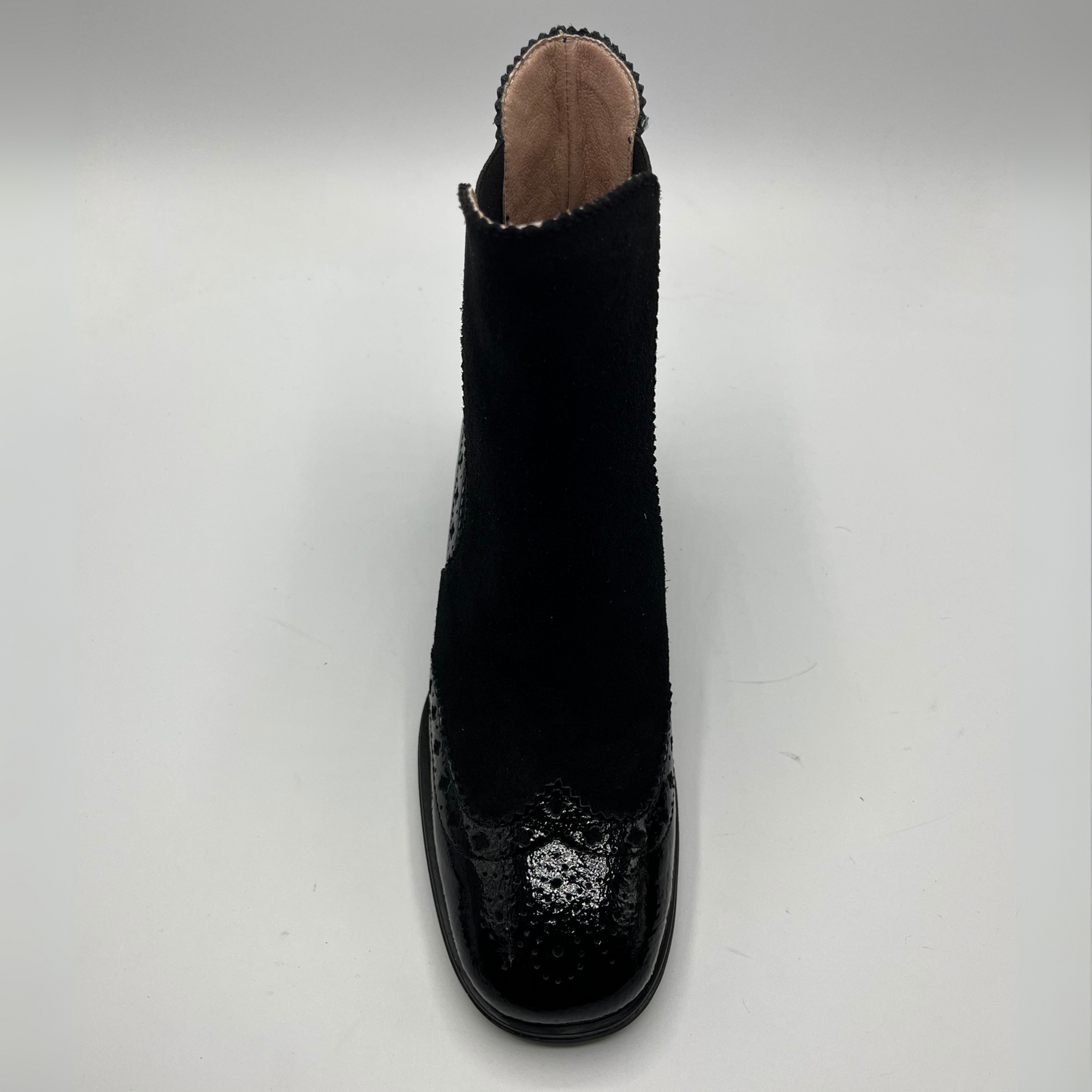 Black ankle boot with patterned sole on a white background