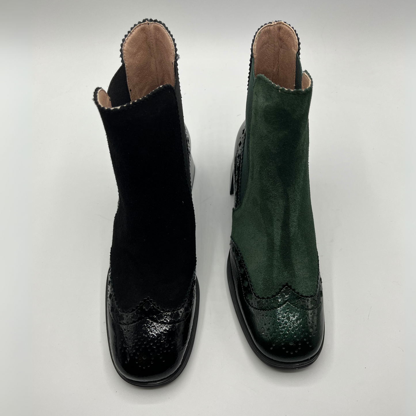 Pair of green and black ankle boots on a white background