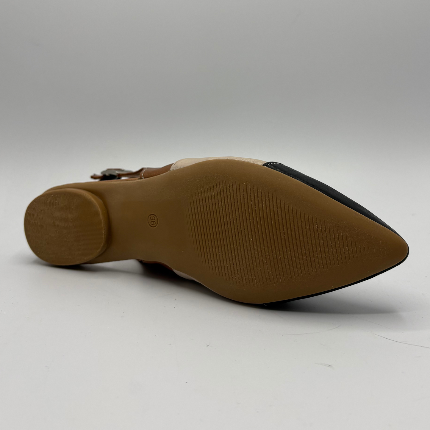 Bottom view of a pointy toe flat shoe with a sling back strap