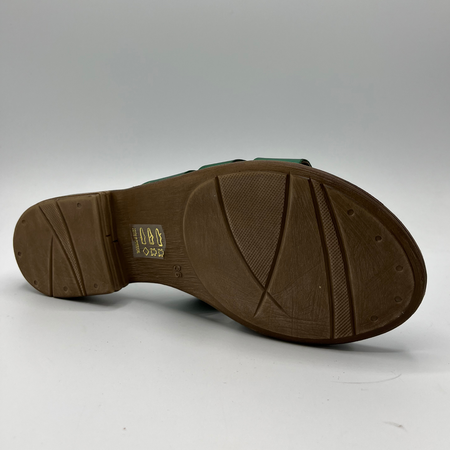 Bottom view of a leather slip on sandal in emerald green with a low stacked heel, and cushioned leather lined insole
