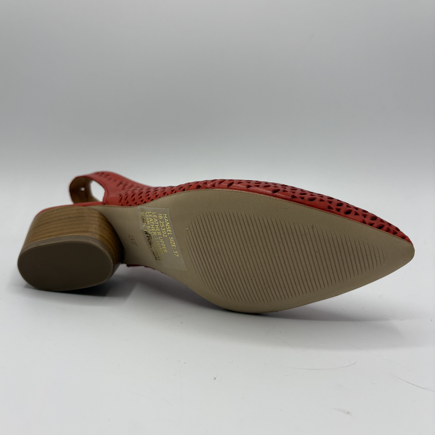 Red shoe with textured sole on a white background
