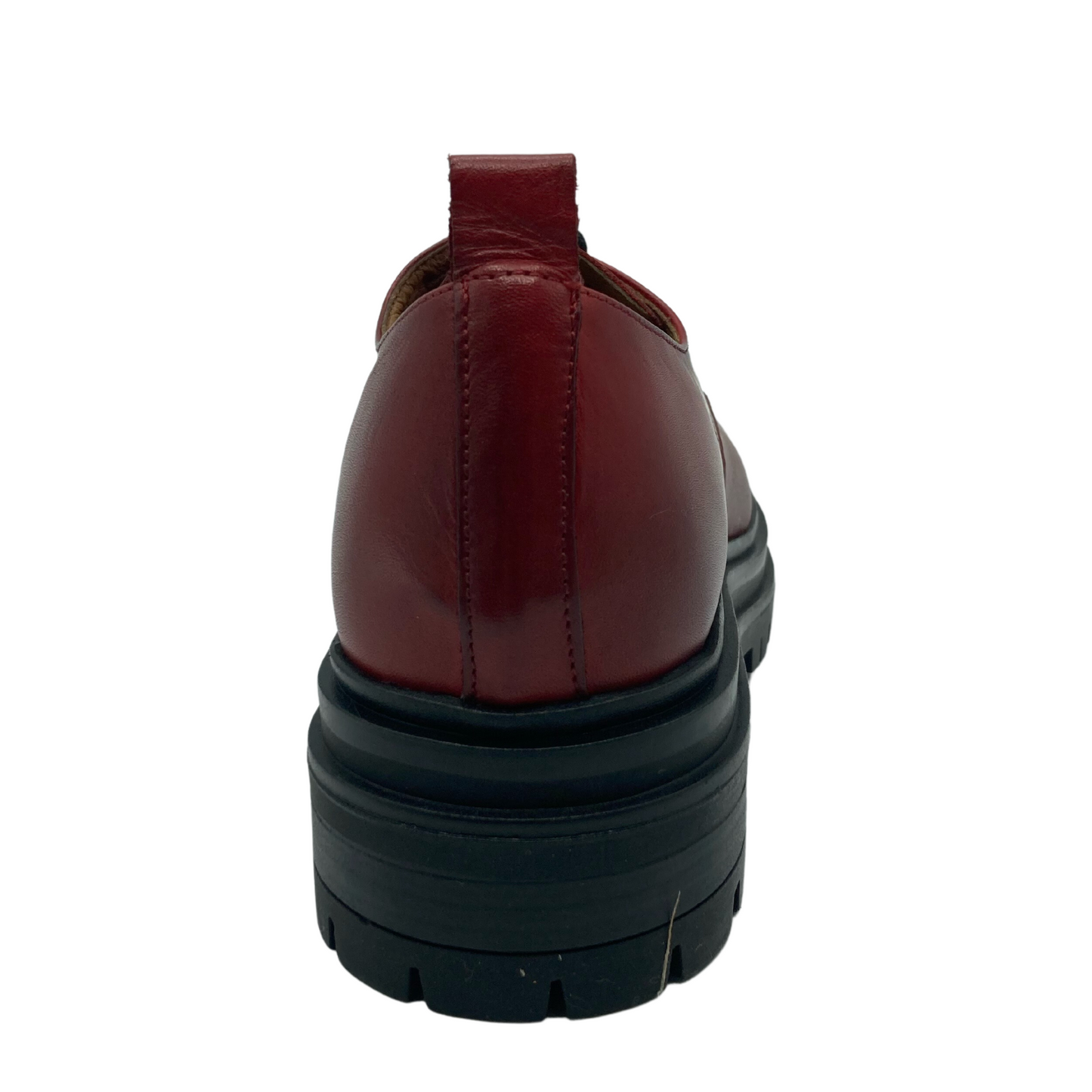 Back view of the heel of red leather loafer with chunky black rubber sole and red pull-on tab