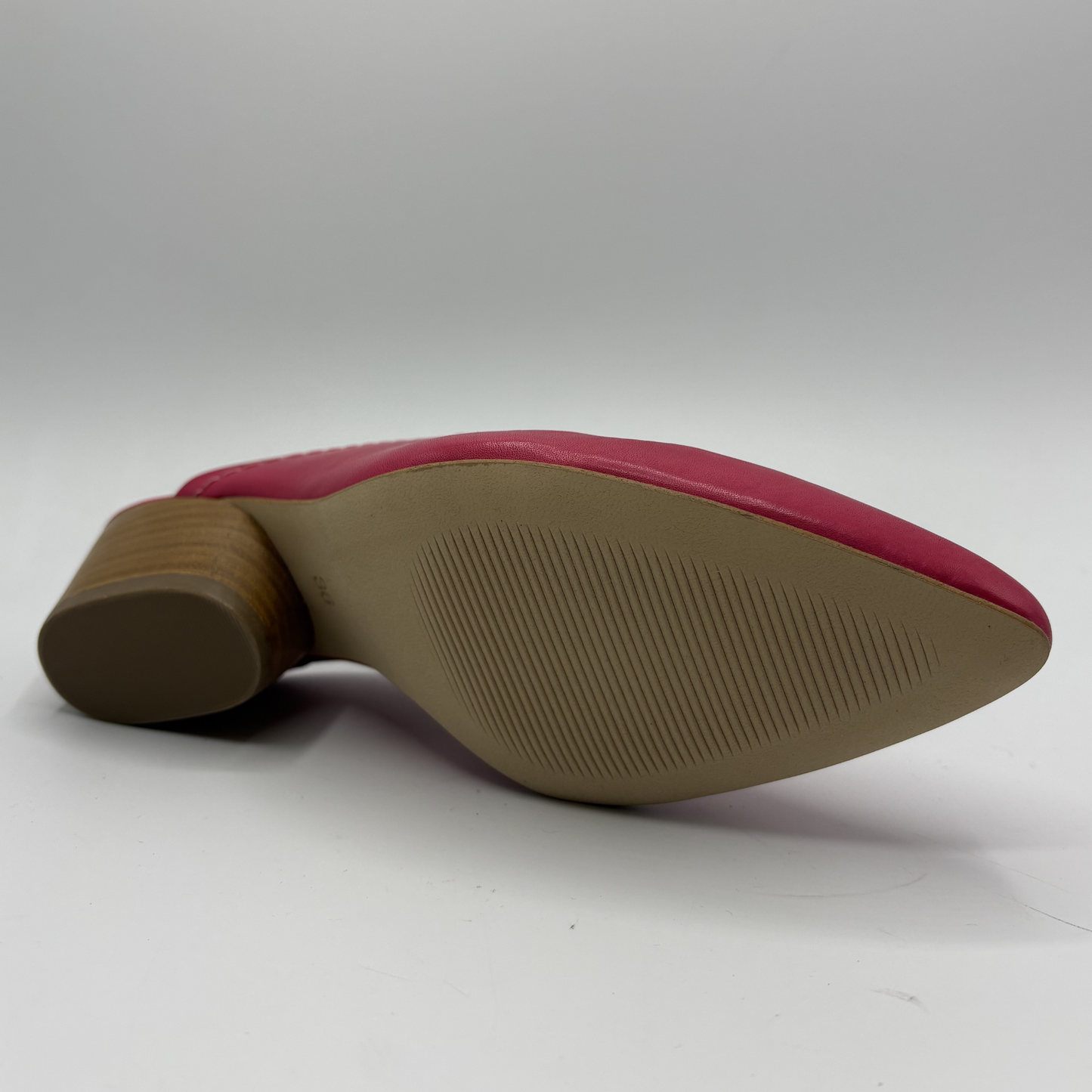 Close-up of a shoe sole with red upper and brown sole on a white background