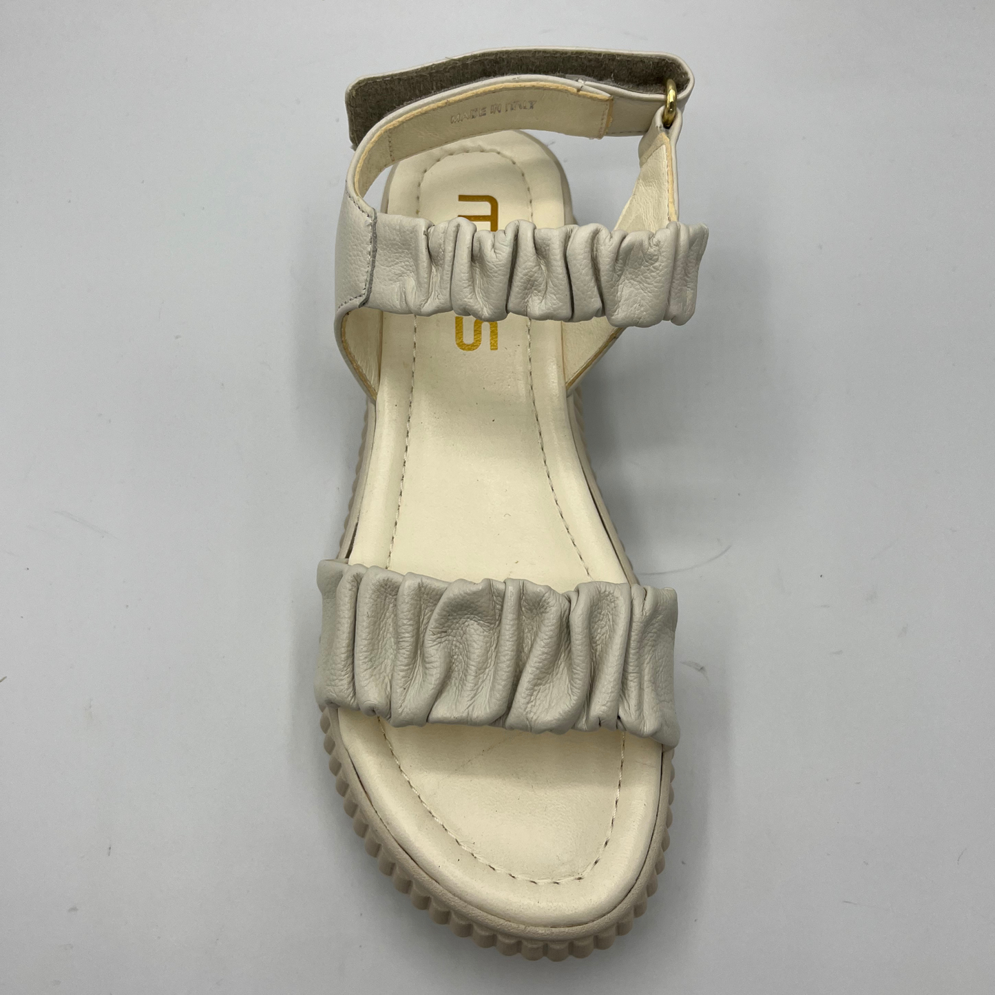 Top view of an ivory coloured leather sandal with a thick platform outsole and an adjustable sling back strap.