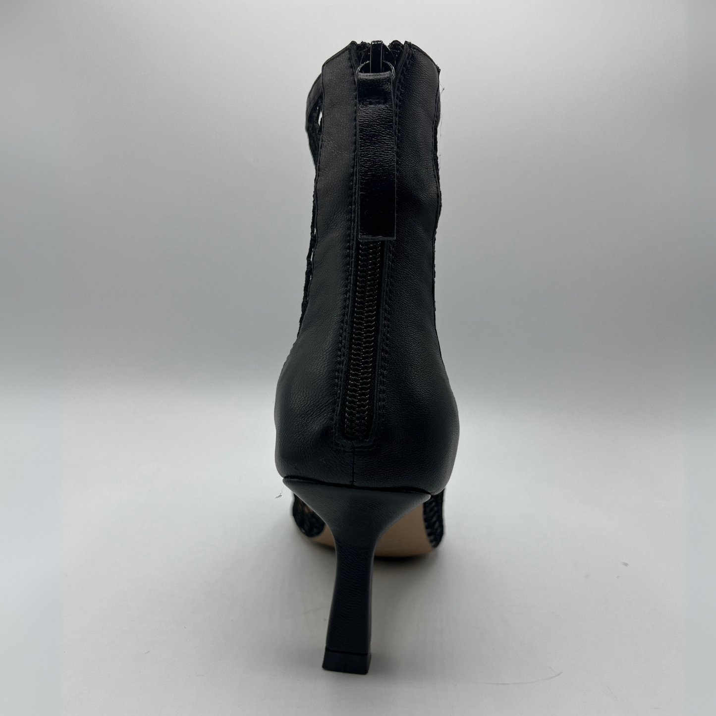 Back view of a black mesh heeled boot