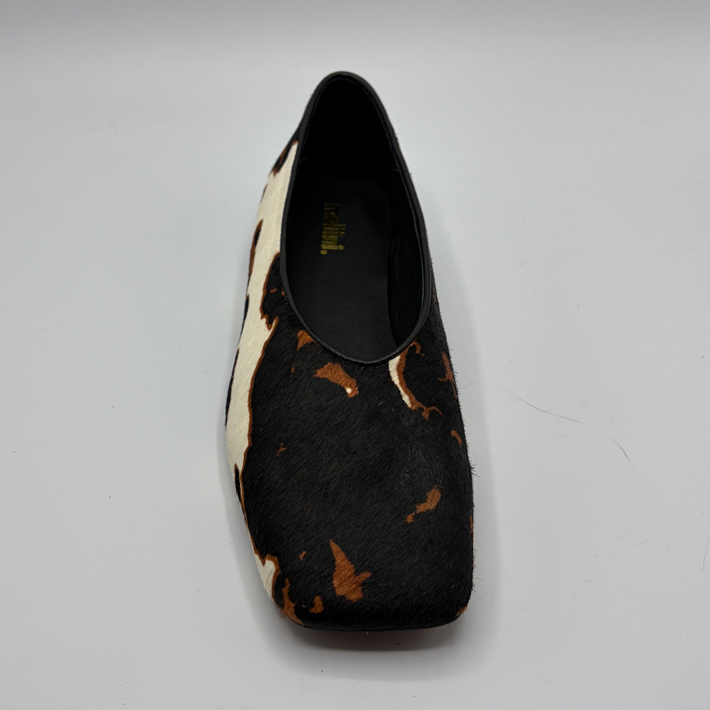 Black and brown patterned shoe on a gray background