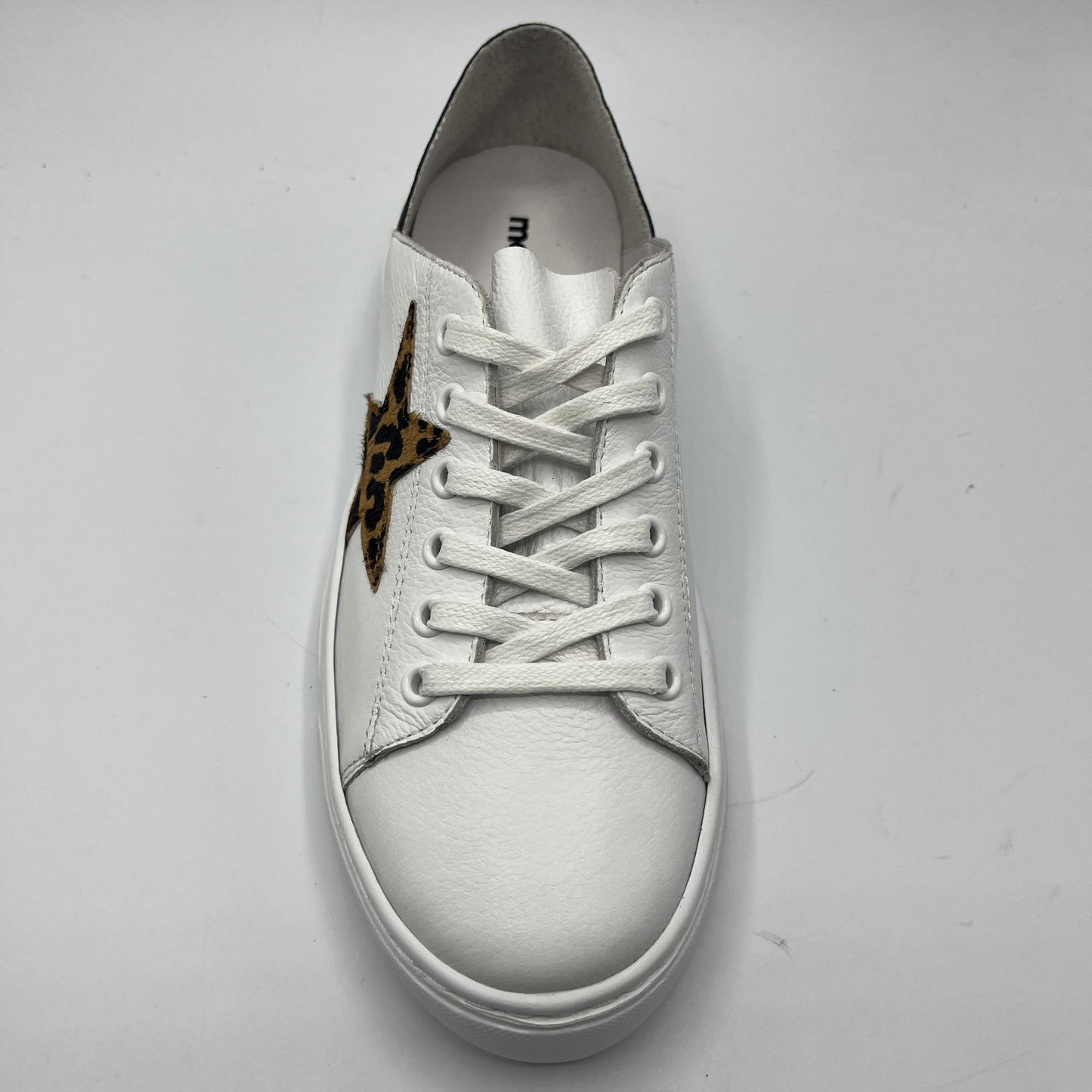 Top view of a white leather sneaker with a white rubber outsole and a leopard print star.