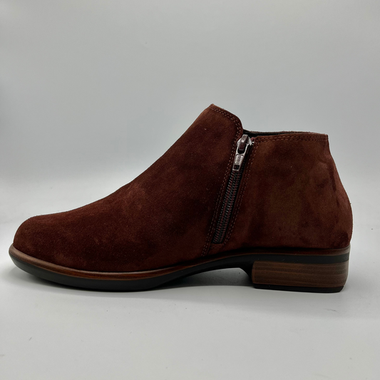 Brown suede ankle boot with a zipper on a gray background