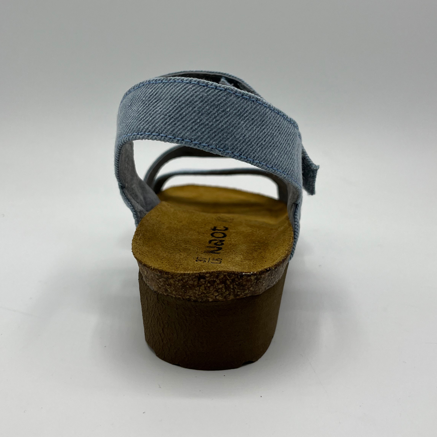 Back view of a light denim strapped sandal with adjustable hook and loop and a low wedge heel.