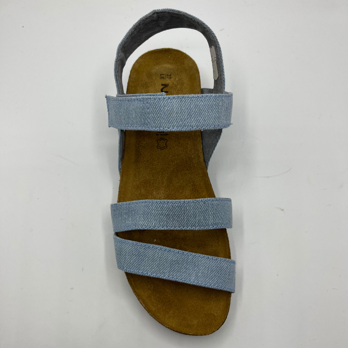Top view of a light denim strapped sandal with adjustable hook and loop and a low wedge heel.