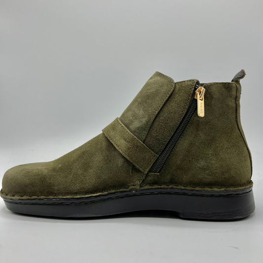 Green suede ankle boot with a gold zipper on a gray background
