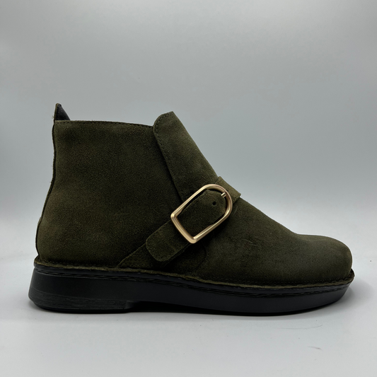 Green suede boot with a gold buckle on a gray background
