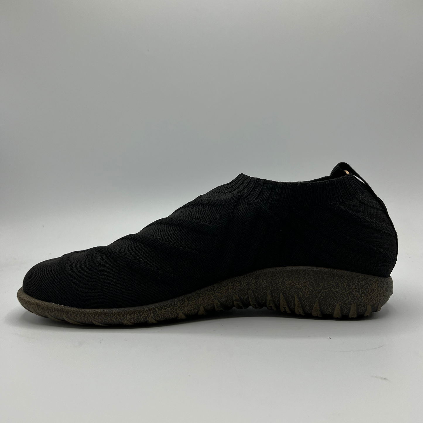 Black slip-on shoe on a gray background