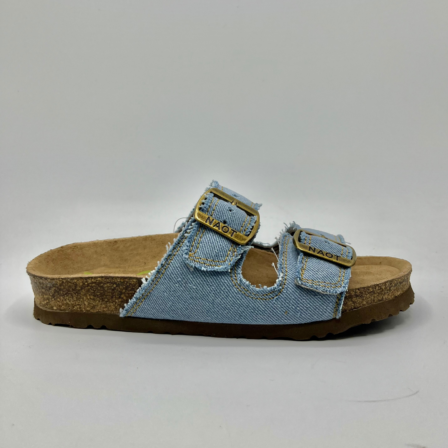 Right facing view of a denim slip on sandal with a contoured cork footbed and two adjustable straps.
