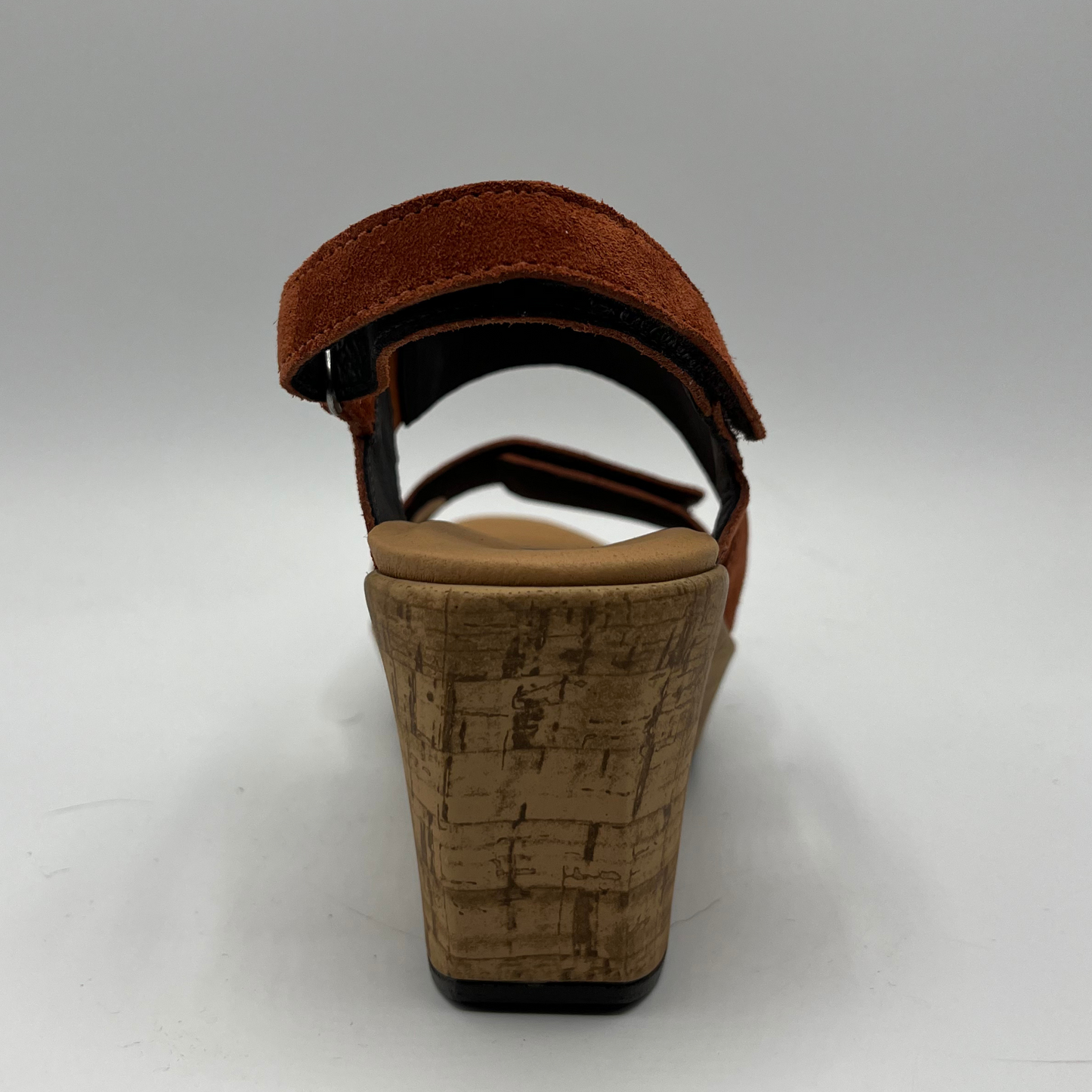 Back view of a suede sandal with a cushioned footed and hook and loop adjustable straps on the ankle and toe.