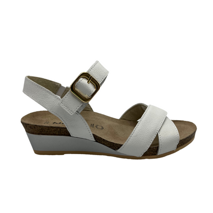 Right facing view of white leather strapped sandal with gold buckle and wedge heel.