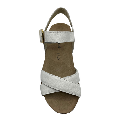 Top view of white leather strapped sandal with gold buckle and wedge heel.