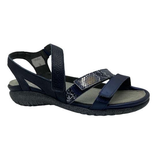 45 degree angled view of navy leather sandal with 3 velcro straps, wedge sole and metallic detail