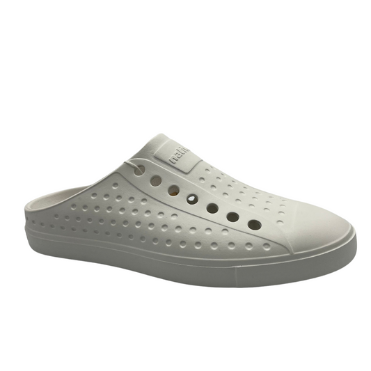 Angled view of white slip on summer shoe. Perforated upper and rounded toe